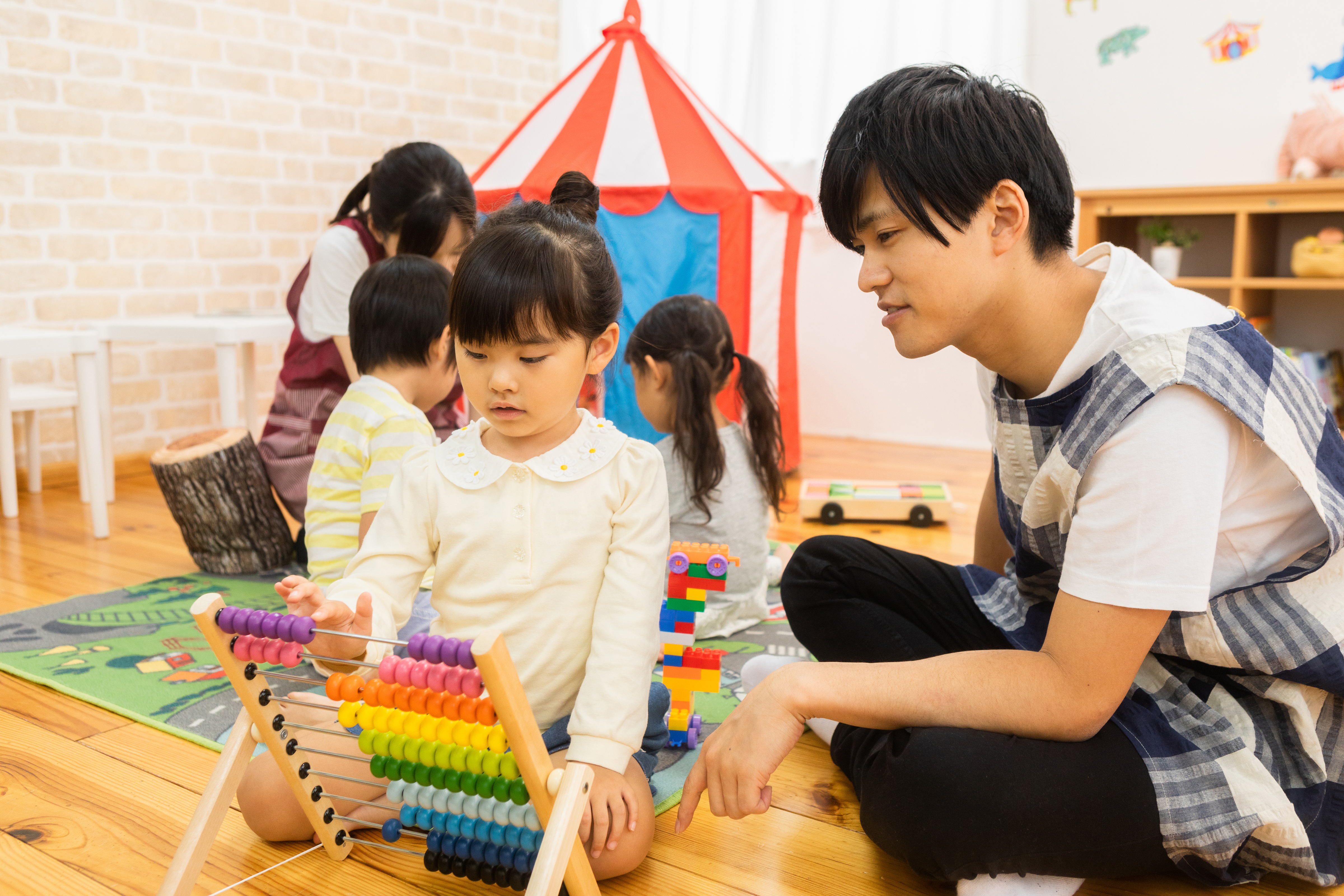 A teacher and young learner playing with building blocks